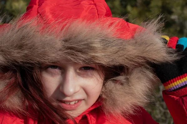 Portrait of a cute little girl of 8-9 years old, wearing bright red jacket — Stock Photo, Image