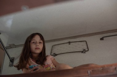 Trenin en üst rafında yatan tatlı kız. Yaz tatili. Kız akıllı telefondan selfie çekiyor..
