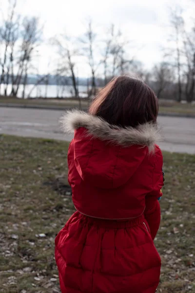Portrait of a cute little girl of 8-9 years old, wearing bright red jacket — Stock Photo, Image