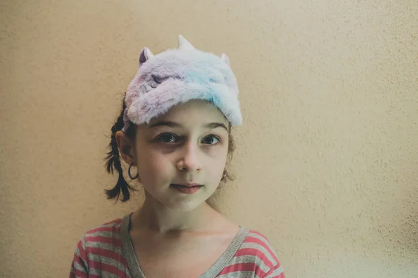 Fată cu păr drept, cu un plasture de dormit moale alb Unicorn pe față. Fata cu o mască de somn unicorn. 9 ani . — Fotografie, imagine de stoc