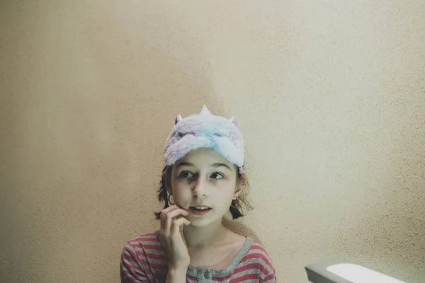 Girl with straight hair with a soft white sleeping patch Unicorn on her face. Girl in a unicorn sleep mask. 9 years old. — 스톡 사진