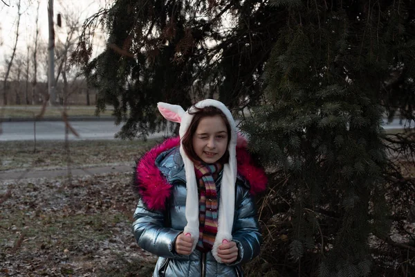 Niedliches kleines Mädchen mit Kapuze und Ohren. Mädchen in einer Huthasenstraße — Stockfoto