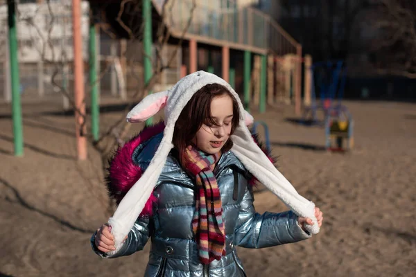 Söt liten flicka i huva med öron. flicka i en hatt kanin gata — Stockfoto