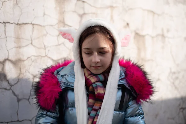 Niedliches kleines Mädchen mit Kapuze und Ohren. Mädchen in einer Huthasenstraße — Stockfoto