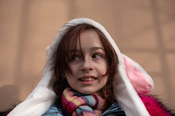 Linda niña en la capucha con orejas. chica en un sombrero conejito calle — Foto de Stock