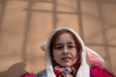 Kulakları olan kapüşonlu şirin bir kız. Tavşan sokağındaki kız.