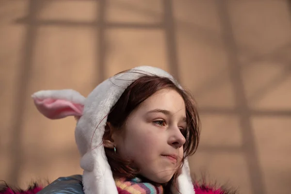 Linda niña en la capucha con orejas. chica en un sombrero conejito calle — Foto de Stock