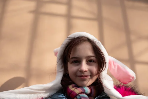 Roztomilá holčička v kapuci s ušima. dívka v klobouku králík ulice — Stock fotografie