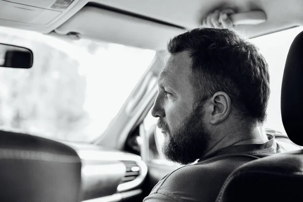 Attractive man in good car. Man with a beard in a car. Do not distract the driver