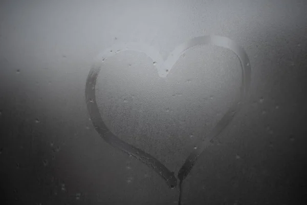 Il cuore è dipinto sul vetro appannato in inverno — Foto Stock