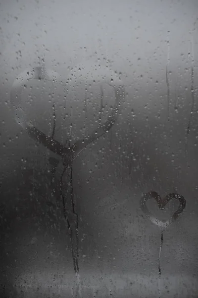 Il cuore è dipinto sul vetro appannato in inverno — Foto Stock