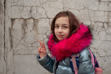 Sırt çantalı kız öğrenci. Okul çantalı ve kışlık ceketli bir kız.