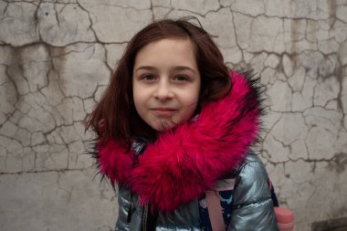 Sırt çantalı kız öğrenci. Okul çantalı ve kışlık ceketli bir kız.