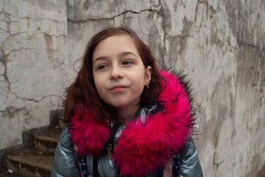 Sırt çantalı kız öğrenci. Okul çantalı ve kışlık ceketli bir kız.