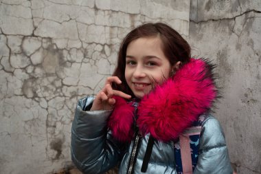 Sırt çantalı kız öğrenci. Okul çantalı ve kışlık ceketli bir kız.