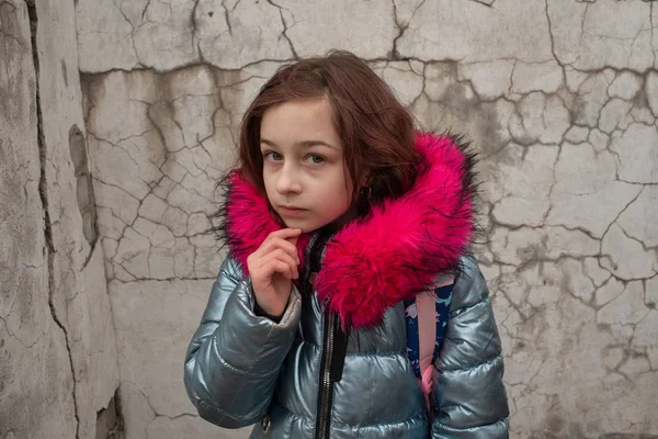 Colegiala con mochila. Chica en una chaqueta de invierno y una mochila escolar — Foto de Stock