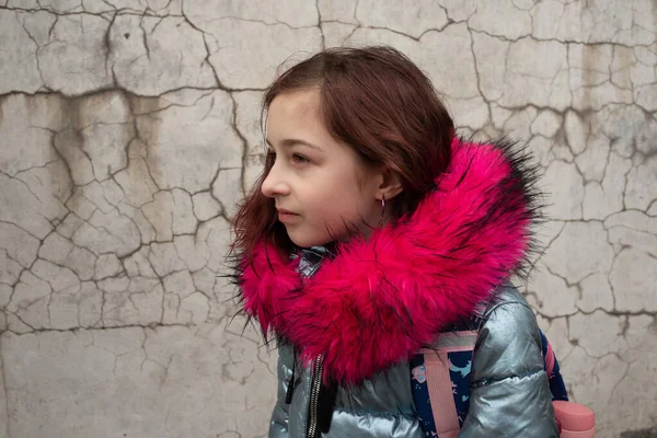Colegiala con mochila. Chica en una chaqueta de invierno y una mochila escolar — Foto de Stock