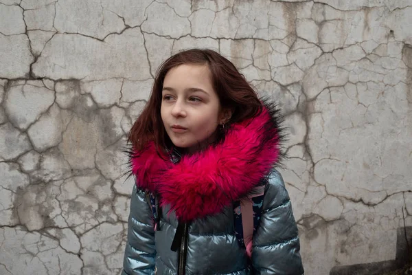 Colegiala con mochila. Chica en una chaqueta de invierno y una mochila escolar — Foto de Stock