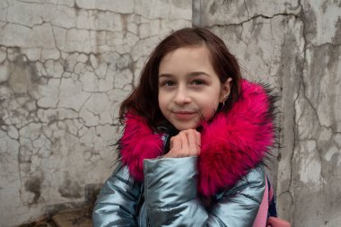 Sırt çantalı kız öğrenci. Okul çantalı ve kışlık ceketli bir kız.