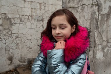 Sırt çantalı kız öğrenci. Okul çantalı ve kışlık ceketli bir kız.