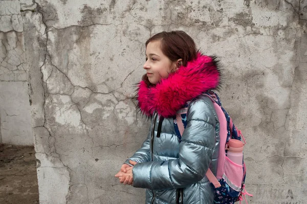 Colegiala con mochila. Chica en una chaqueta de invierno y una mochila escolar — Foto de Stock