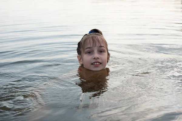 Placer hermosa niña nadar en agua azul, inclinarse fuera del agua y sonreír. Adolescente chica disfruta del clima cálido —  Fotos de Stock