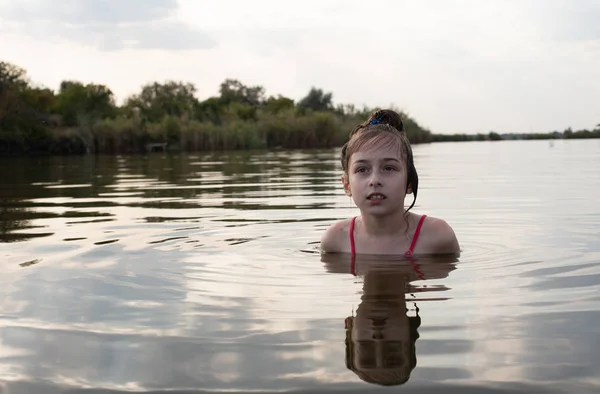 Placer hermosa niña nadar en agua azul, inclinarse fuera del agua y sonreír. Adolescente chica disfruta del clima cálido —  Fotos de Stock