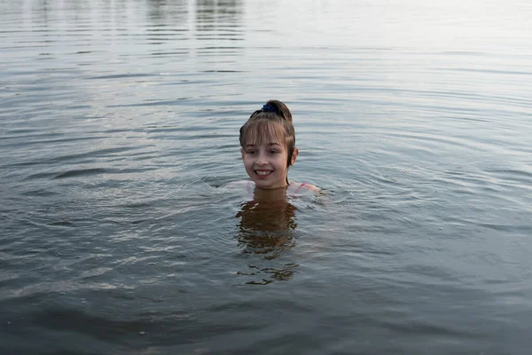 Plăcere fetiță frumoasă înoată în apă albastră, se apleacă din apă și zâmbește. Adolescenta fata se bucură de vreme caldă — Fotografie, imagine de stoc