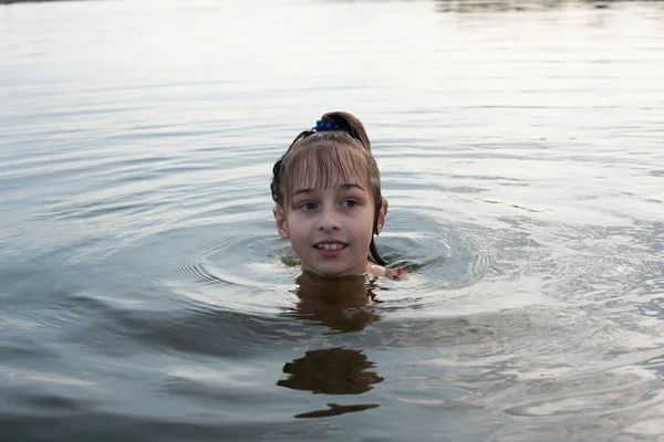 Prazer linda menina nadar em água azul, inclinar-se para fora da água e sorrir. Adolescente menina goza do clima quente — Fotografia de Stock