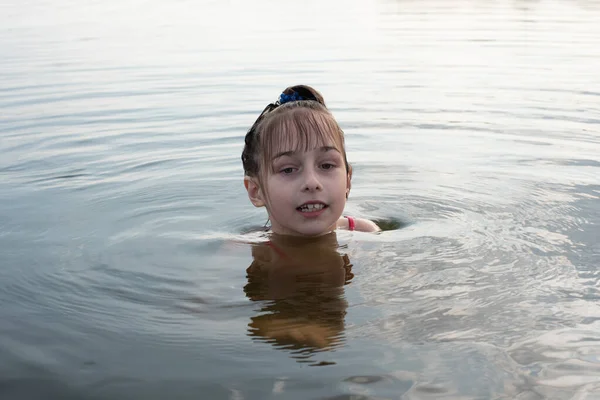 Plaisir belle petite fille nager dans l'eau bleue, maigre hors de l'eau et sourire. Adolescente bénéficie du temps chaud — Photo