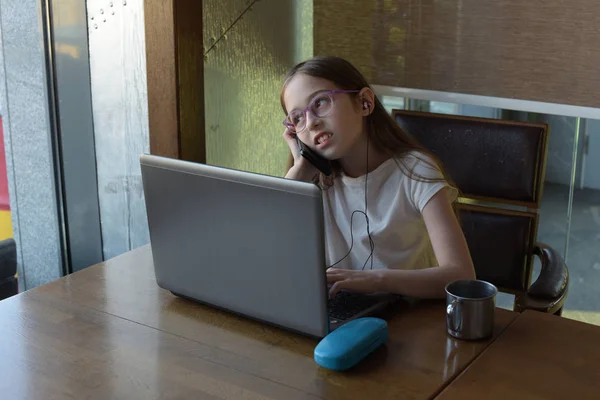 O tânără fermecătoare femeie care folosește laptopul în timp ce stă în interiorul cafenelei moderne. Fata si laptop . — Fotografie, imagine de stoc