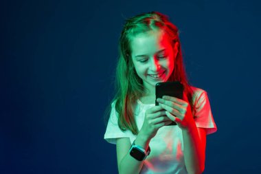 Ergen akıllı telefondan konuşuyor. Elinde akıllı bir telefon olan bir kız. Kırmızı yeşil bir filtrenin elinde akıllı telefonu olan bir kız. Smartwatch. 9 yaşındaki bir kız telefonda kendi fotoğrafını çekiyor.