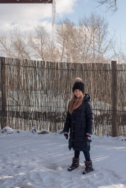 Soğuk mevsimde şehrin arka planında şapkalı güzel bir sarışının portresi. Sokakta yürüyen bir kız. Kışın siyah şapkalı ve mavi ceketli bir kız. 9 yaşında bir kız..