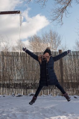 Soğuk mevsimde şehrin arka planında şapkalı güzel bir sarışının portresi. Sokakta yürüyen bir kız. Kışın siyah şapkalı ve mavi ceketli bir kız. 9 yaşında bir kız..