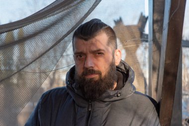 Sokakta gri ceketli sakallı bir adam. Bir adamın portresi. Sakallı adam. Kış, kış ceketi, sakal