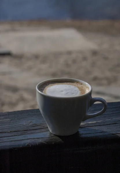 Coffee selective focus. White cup with cappuccino on the nature. White cup with cappuccino, coffee, morning, cheerfulness.