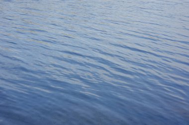 Su, göl, dalga, arka plan. Nehir suyu dokusu. Nehirdeki parlak ve yansıtıcı yüzey suyu. Nehir veya deniz suyunun küçük dalgalı soyut arkaplanı. su dokusu