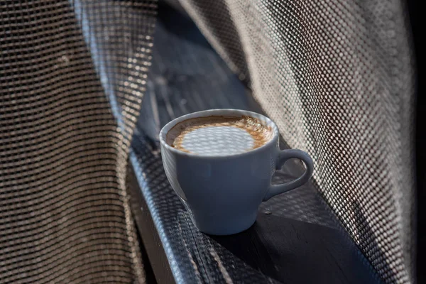 Coffee selective focus. White cup with cappuccino on the nature. White cup with cappuccino, coffee, morning, cheerfulness.