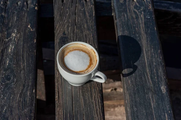 Coffee selective focus. White cup with cappuccino on the nature. White cup with cappuccino, coffee, morning, cheerfulness.