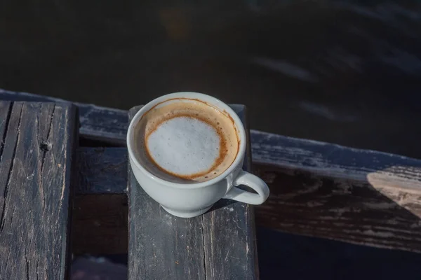 Coffee selective focus. White cup with cappuccino on the nature. White cup with cappuccino, coffee, morning, cheerfulness.