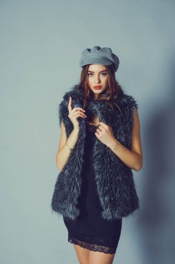 Güzel bir genç kadının muhteşem portresi. Mükemmel yüz güzel kız portresi. Esmer kız. Gri şapkalı kız. Küçük siyah elbise. Sahte kürklü yelekli kız..
