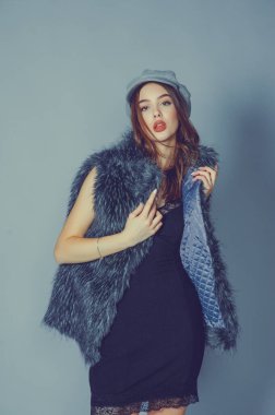 Güzel bir genç kadının muhteşem portresi. Mükemmel yüz güzel kız portresi. Esmer kız. Gri şapkalı kız. Küçük siyah elbise. Sahte kürklü yelekli kız..