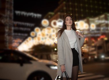 Şehir ışıklarında seksi esmer kız portresi. Uzun siyah saçlı, güzel bir kadının Vogue tarzı portresi. Sığ DOF. Kız ve gece şehri. Gece şehri. Portre