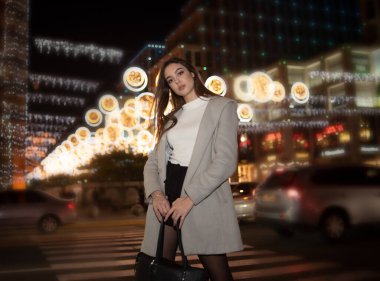 Şehir ışıklarında seksi esmer kız portresi. Uzun siyah saçlı, güzel bir kadının Vogue tarzı portresi. Sığ DOF. Kız ve gece şehri. Gece şehri. Portre