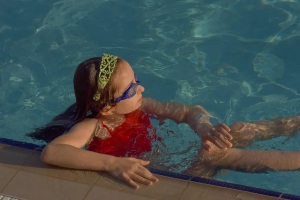 スイミングプールでゴーグルとかわいい女の子 女の子はゴーグルでプールで泳ぐ プール リラクゼーション ウォーターパーク リラクゼーションエリア 赤ん坊は泳いでいる ホーリー — ストック写真