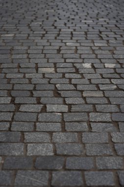 Gri kaldırım taşlarıyla döşenmiş eski Avrupa avlusu. Pavers dokusu. Sokak Yolu 'nun zeminindeki monoton gri tuğla kaldırıma bir bakış açısı. Kaldırımlar, garaj yolu, kaldırımlar