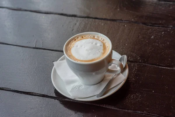 木製のテーブルの上にソーサーにコーヒーとホワイトカップ 木製のテーブルの上にソーサー付きの白いカップ — ストック写真
