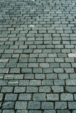 Gri kaldırım taşlarıyla döşenmiş eski Avrupa avlusu. Pavers dokusu. Sokak Yolu 'nun zeminindeki monoton gri tuğla kaldırıma bir bakış açısı. Kaldırımlar, garaj yolu, kaldırımlar
