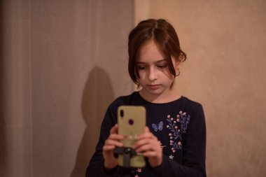 Mutlu genç bir kadın beyaz arka planda selfie çekiyor. Kız monopod ya da selfie çubuğuyla kendi videosunu çekiyor. Blogcu. Vlog. Kız internet ya da internet ağları için video çekiyor. Portre