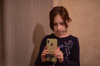 Mutlu genç bir kadın beyaz arka planda selfie çekiyor. Kız monopod ya da selfie çubuğuyla kendi videosunu çekiyor. Blogcu. Vlog. Kız internet ya da internet ağları için video çekiyor. Portre